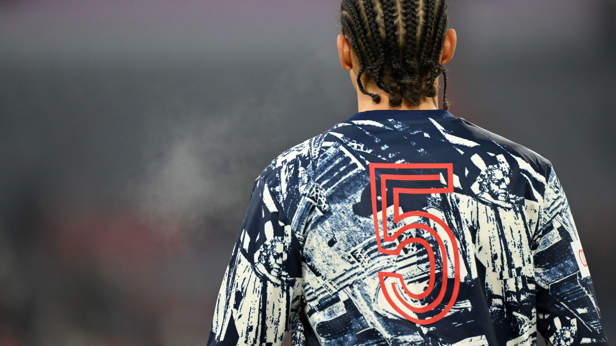 MUNICH, GERMANY - JANUARY 12: Leroy Sane of Bayern Munich warms up whilst wearing a shirt which displays the number '5' after the passing of former German football player and manager, Franz Beckenbauer, prior to the Bundesliga match between FC Bayern München and TSG Hoffenheim at Allianz Arena on January 12, 2024 in Munich, Germany. (Photo by Sebastian Widmann/Getty Images)