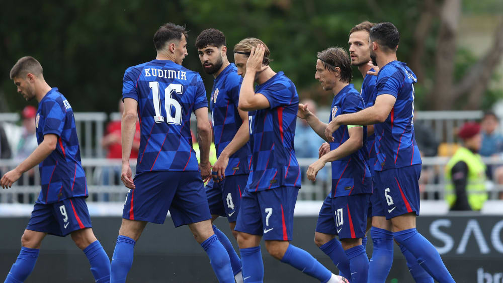Teammates congratulate Luka Modric (#10) on his opening goal.