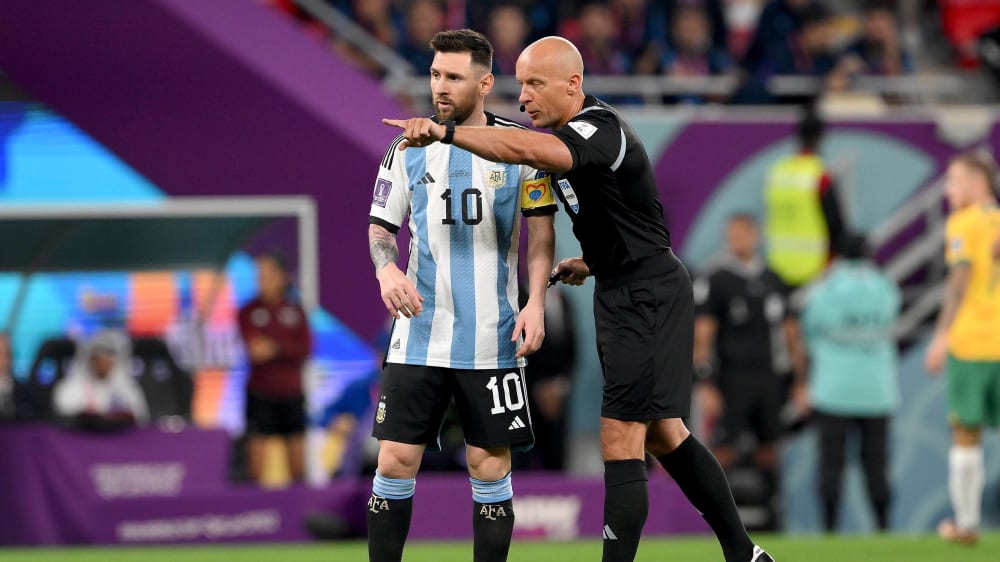Da lang geht's zum Finale: WM-Finalschiedsrichter Szymon Marciniak zeigt Lionel Messi den Weg.