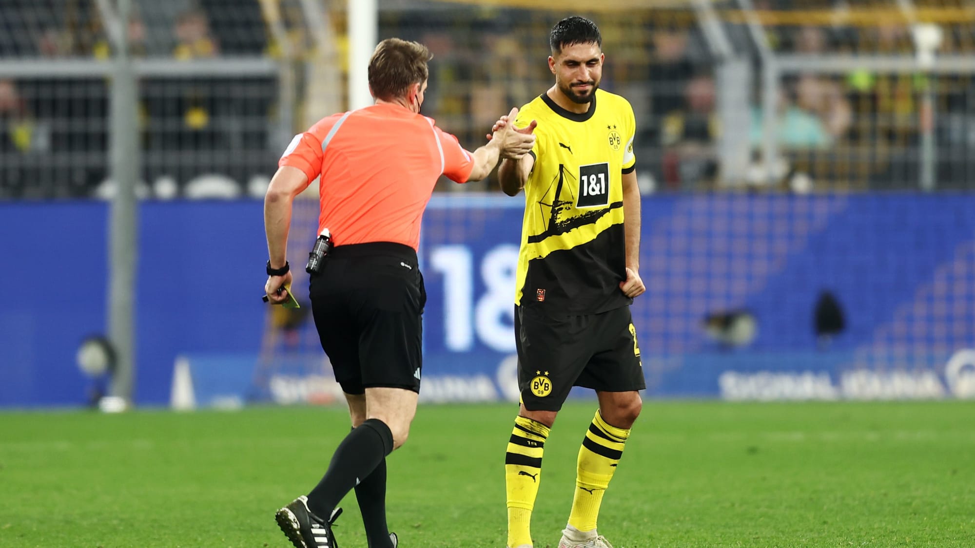 Tobias Stieler (rot) und Emre Can beim Handshake