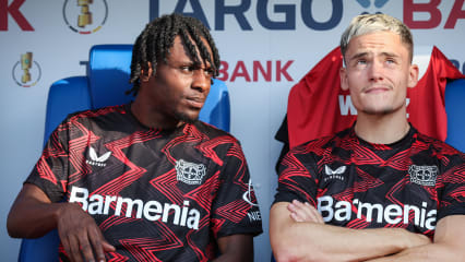 JENA, GERMANY - AUGUST 28: Jeremie Frimpong (L) and Florian Wirtz (R) of Bayer 04 Leverkusen sit on the bench prior to the DFB-Pokal match between FC Carl Zeiss Jena and Bayer 04 Leverkusen at Ernst-Abbe-Sportfeld on August 28, 2024 in Jena, Germany. (Photo by Ronny Hartmann/Getty Images)