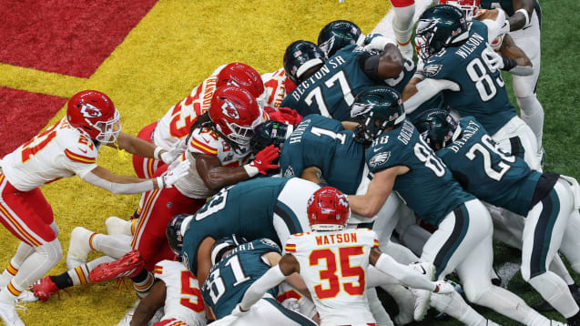  Eagles-Quarterback Jalen Hurts wird von seinen Teamkollegen über die Goal Line gedrückt.