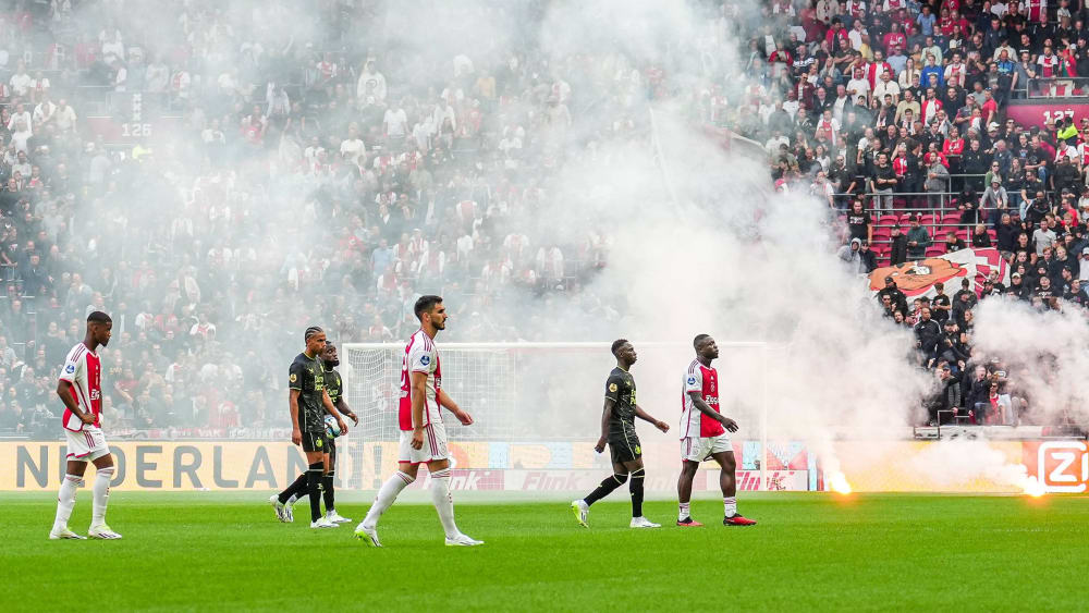 Ajax-Anhänger warfen im Klassieker Leuchtraketen auf den Platz. Die Spieler gingen daraufhin in die Katakomben.