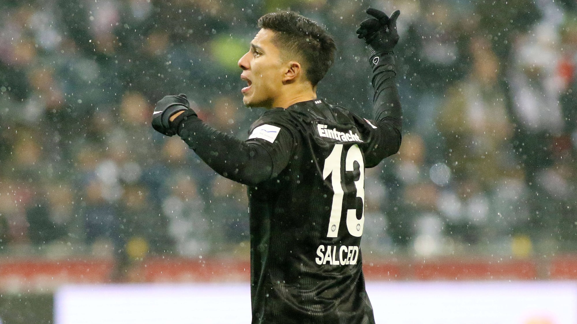 Carlos Salcedo gestikuliert im alten schwarzen Dress von Eintracht Frankfurt im Regen stehend.&nbsp;