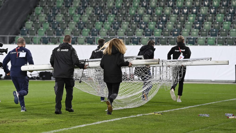 Da h&#228;tte das Spiel schon laufen sollen: Helfer tragen ein fehlerhaftes Tor aus dem Stadion in St. Gallen.