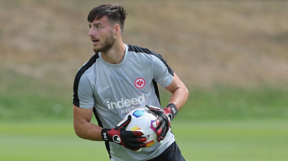 Diant Ramaj hält den Ball im einen Training von Eintracht Frankfurt in seinen Händen.