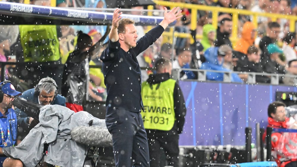 Ein Unwetter über Dortmund sorgte für eine lange Unterbrechung des DFB-Spiels gegen Dänemark: Auch Bundestrainer Julian Nagelsmann steht im Regen.