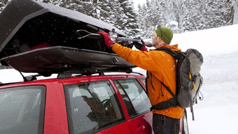 Winterurlaub mit dem Auto: Skier und Snowboards sind in einer Dachbox am besten untergebracht.
