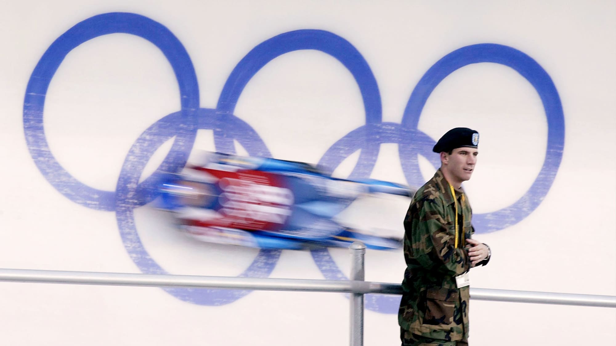 Soldat vor Rodler und Olympischem Logo