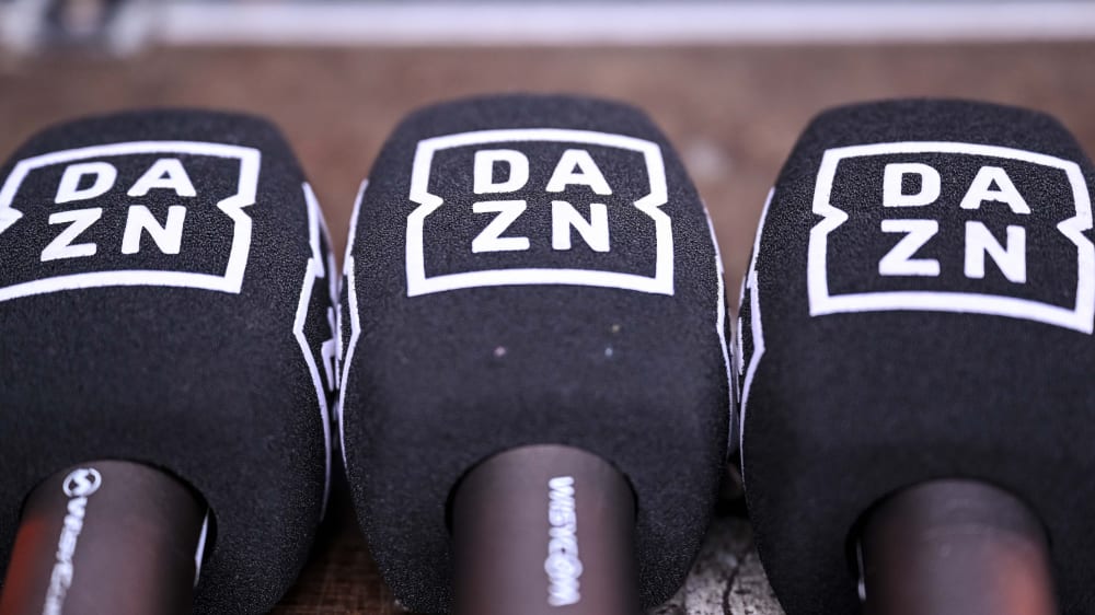 Drei Mikrofone mit dem Logo von DAZN.