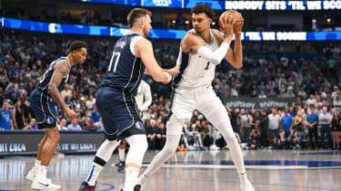 San Antonio Spurs' Victor Wembanyama, right, is defended by Dallas Mavericks' guard Luka Doncic, front left, during the first half of an NBA basketball game, Thursday, Oct. 24, 2024, in Dallas, Texas. (AP Photo/Albert Pena)