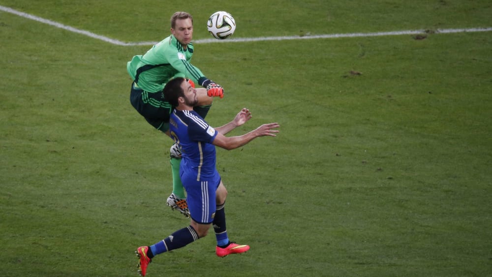 Manuel Neuer räumt Gonzalo Higuain weg.