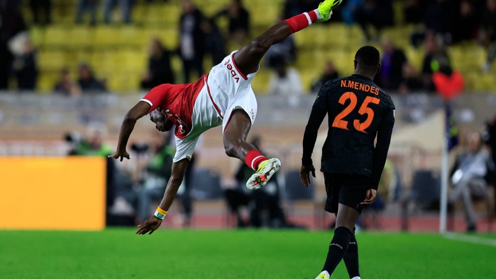 Monaco's Wilfried Singo (left) in an aerial duel with Nuno Mendes.