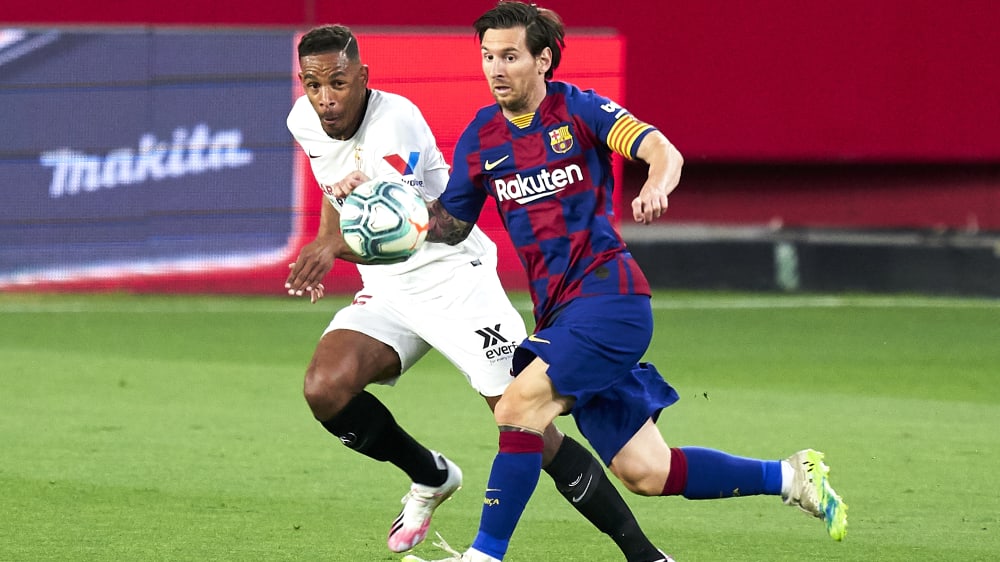 Den Ball im Blick: Sevillas Fernando im Zweikampf mit Messi (r.).