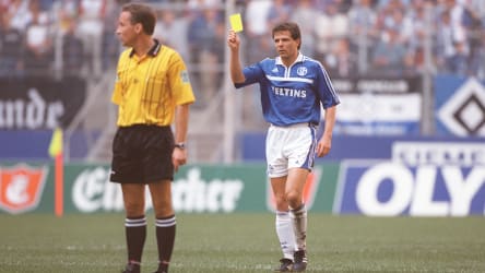 Bundesliga-Schiedsrichter Lutz Wagner sieht die Gelbe Karte vom Schalker Andreas Möller.