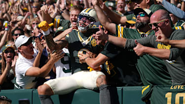 Green Bay Packers wide receiver Christian Watson (9) does a Lambeau Leap after scoring a touchdown against the Chicago Bears on Oct. 11, 2026, at Lambeau Field in Green Bay, Wis. The Packers defeated the Bears 31-7.