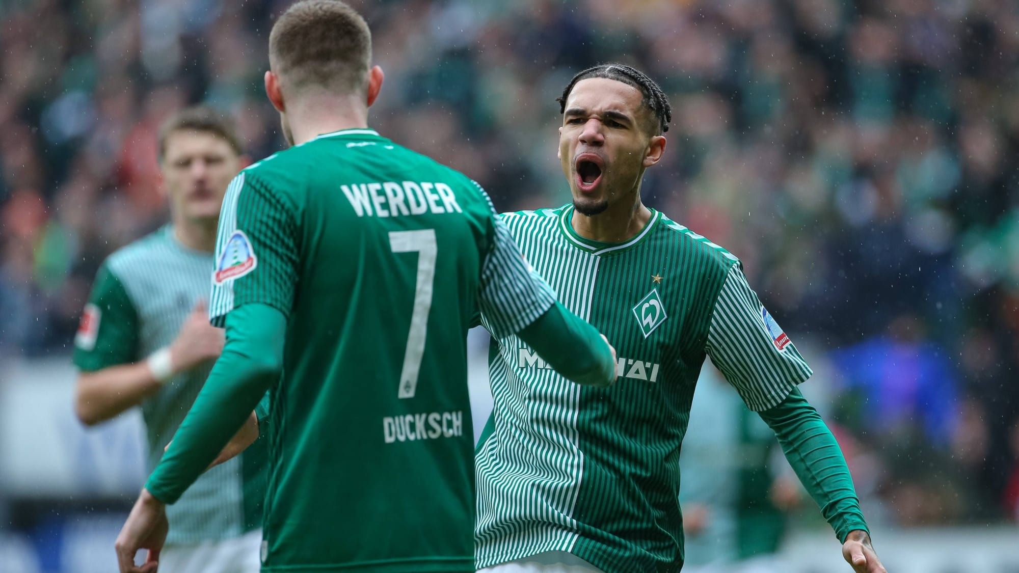 Werder Bremens Angreifer Marvin Ducksch (li.) und Justin Njinmah jubeln gemeinsam.