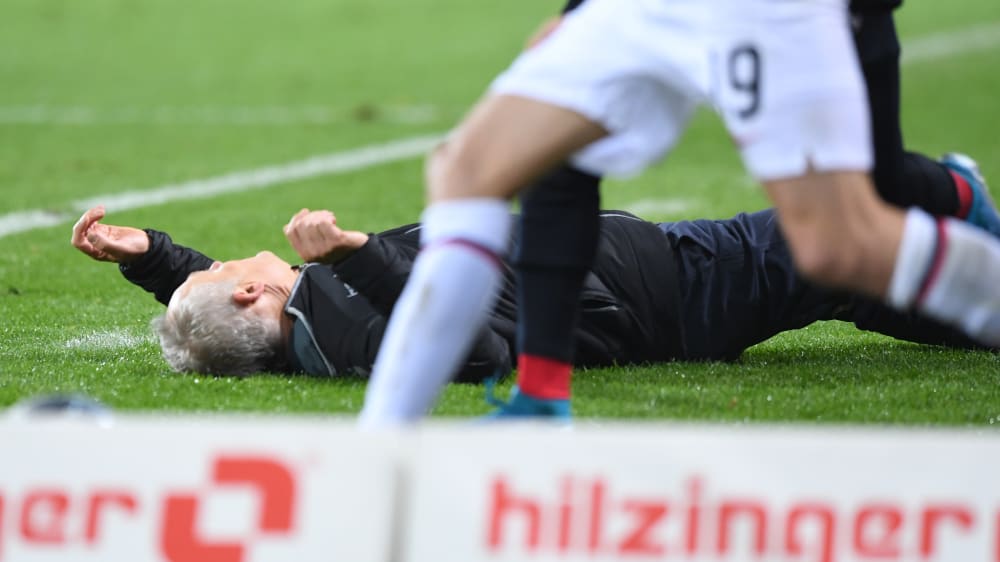 Sekundenbruchteile nach dem heftigen Zusammenprall: SCF-Coach Christian Streich liegt nach der Attacke von David Abraham am Boden.