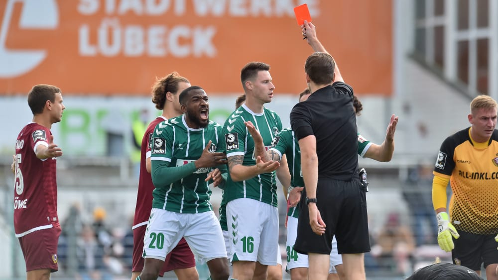 Rot gefällt Osarenren Okungbowa (Nr. 20) gar nicht: Doch Schiedsrichter Dr. Max Bruda schickt Ryan Malone vom Feld.