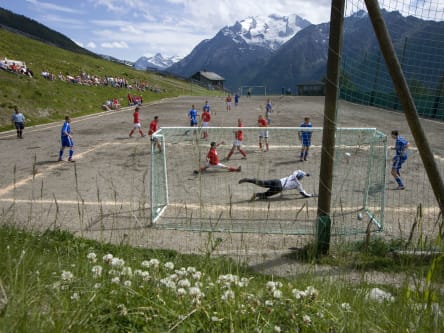 Fußballplatz umgeben von der Schweizer Bergwelt.