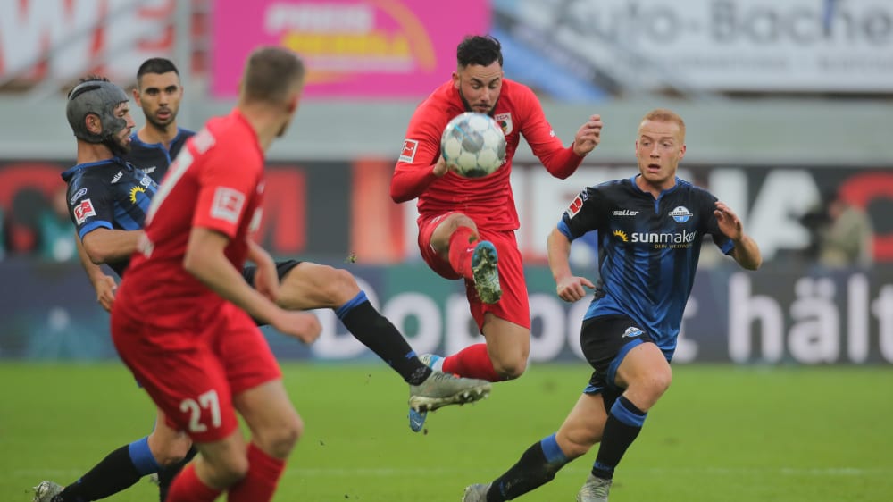 Paderborns Kapitän Klaus Gjasula (verdeckt) kommt gegen Marco Richter (FCA) zu spät.