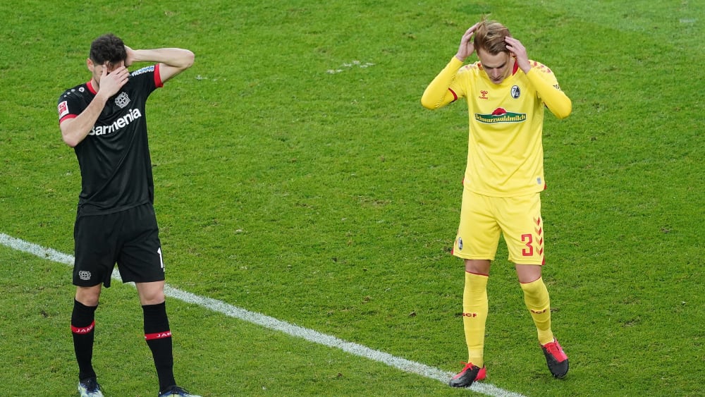 Schmerzhaft: Lucas Alario (l.) und Freiburgs Philipp Lienhart fassen sich an die Köpfe.