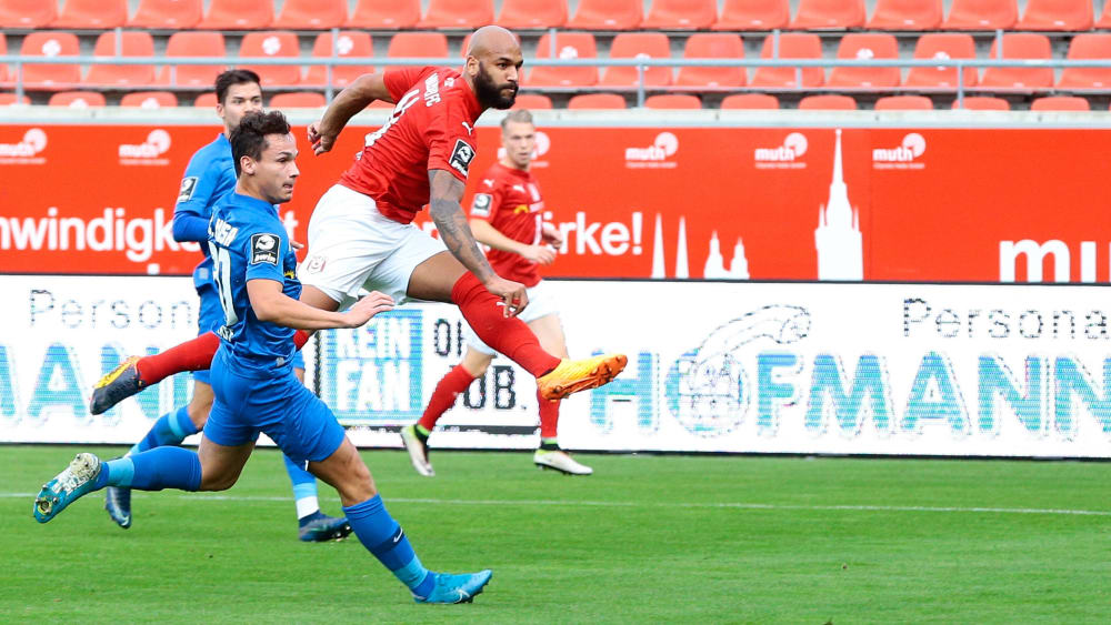 Der Moment des ersten Treffers: Rostocks Lukas Scherff (l.) kommt zu spät, Halles Terrence Boyd (r.) hat schon abgezogen und trifft Sekundenbruchteile später zum 1:0.