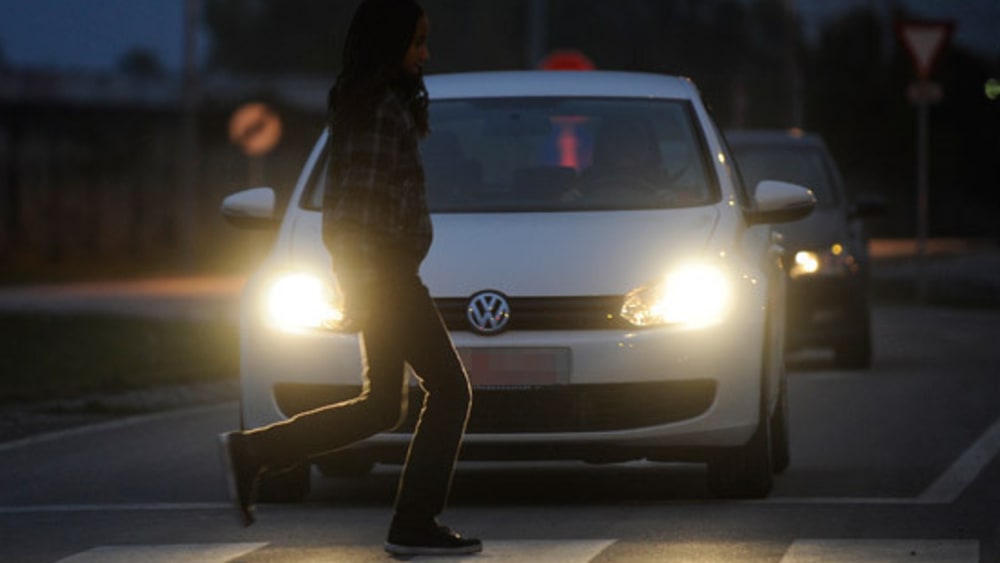 Gefährliche Begegnung: Autofahrer und Fußgänger in der Dunkelheit.