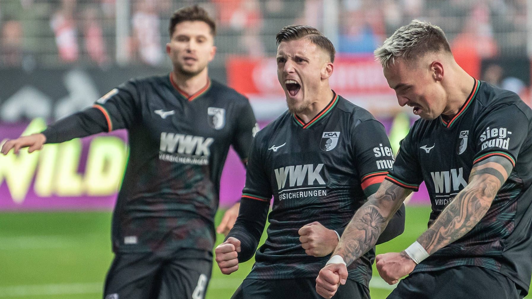 Die Augsburger Elvis Rexhbecaj, Ermedin Demirovic und Philipp Tietz (v.l.) feiern gelöst ein Tor.