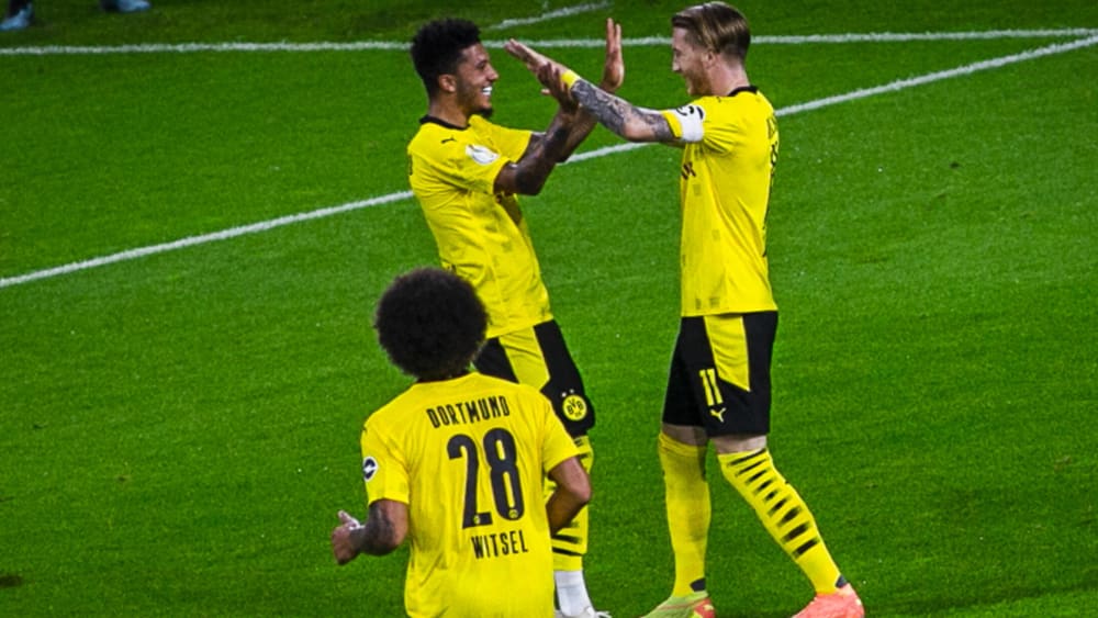 Jadon Sancho und Marco Reus klatschen miteinander ab.