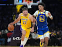 Oct 21, 2026; Los Angeles, California, USA; Los Angeles Lakers guard Luka Doncic (77) drives to the basket against Golden State Warriors forward Yaxel Lendeborg (1) in the first half at Crypto.com Arena. Mandatory Credit: Kirby Lee-Imagn Images