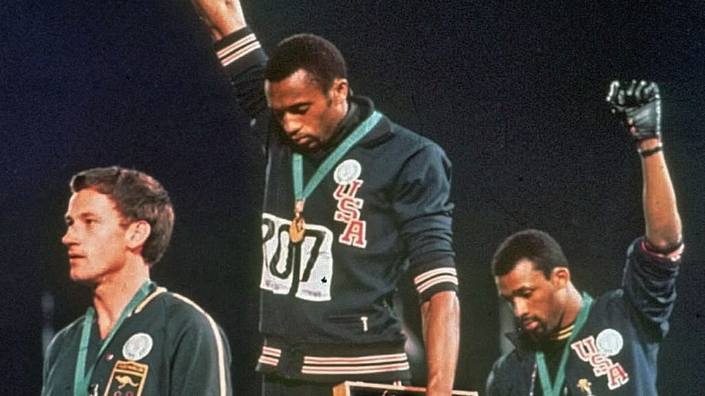 Eines der berühmtesten Bilder der olympischen Geschichte: Tommie Smith (Mi.) und John Carlos (re.) protestieren mit erhobener Faust gegen Rassismus.