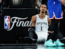 San Antonio Spurs forward Victor Wembanyama sits on the floor after a foul during the second half of Game 5 of the NBA Finals basketball series against the New York Knicks, Saturday, June 13, 2026, in San Antonio. (AP Photo/Ross D. Franklin)