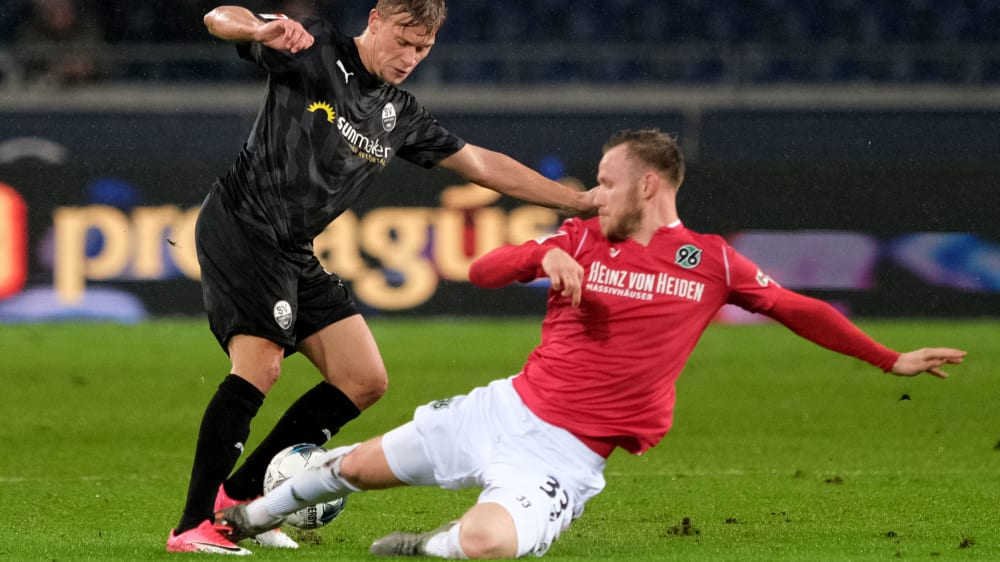 Hannovers Cedric Teuchert grätscht gegen Sandhausens Julius Biada zum Ball.