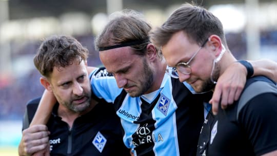 Musst gestützt vom Platz geführt werden: Felix Lohkemper mit Teamarzt Marc Filbert (li.) und Physiotherapeut Cedric Schmidt.