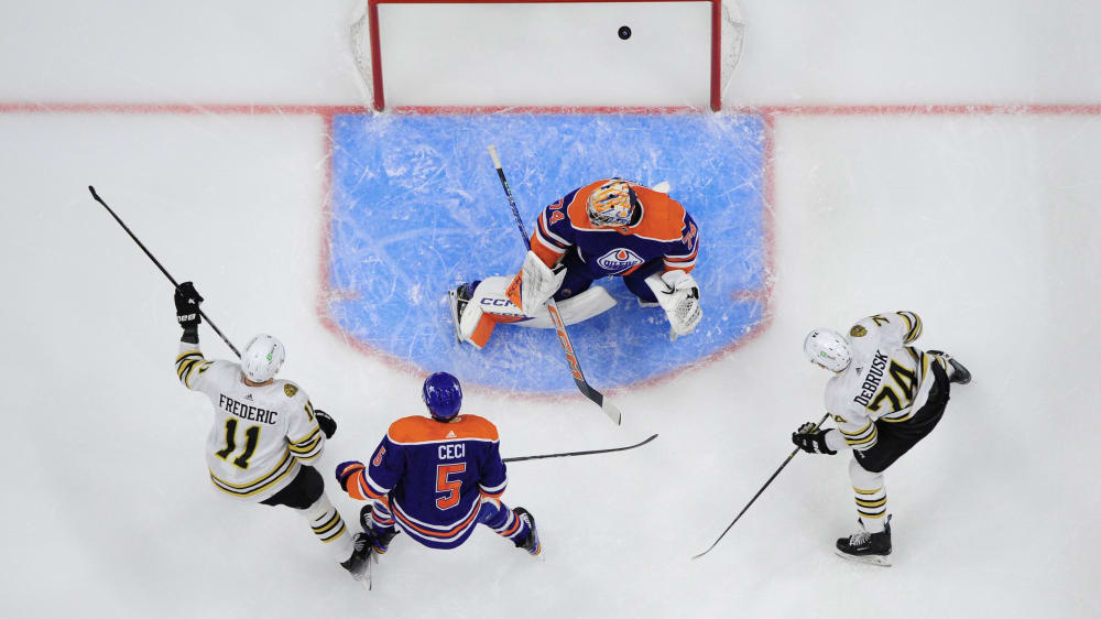 Eines von elf Toren: Trent Frederic von den Boston Bruins (li.) trifft gegen Goalie Stuart Skinner von den Edmonton Oilers zum 3:1.