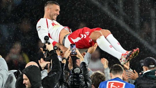 Fußball: Abschiedsspiel von Lukas Podolski beim 1. FC Köln, Mitspieler werfen Lukas Podolski in die Höhe.