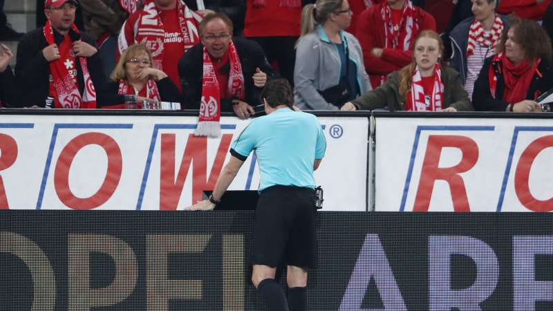 MAINZ, GERMANY - APRIL 16:  Referee Guido Winkmann watches the VAR screen before calling a hand penalty after the half time whistle during the Bundesliga match between 1. FSV Mainz 05 and Sport-Club Freiburg at Opel Arena on April 16, 2018 in Mainz, Germany.  (Photo by Alex Grimm/Bongarts/Getty Images)