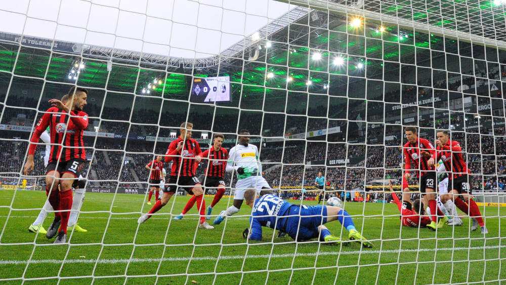 Freiburg-Keeper Mark Flekken (am Boden) wehrt kurz ab, Gladbachs Marcus Thuram (Mitte) staubt ab.