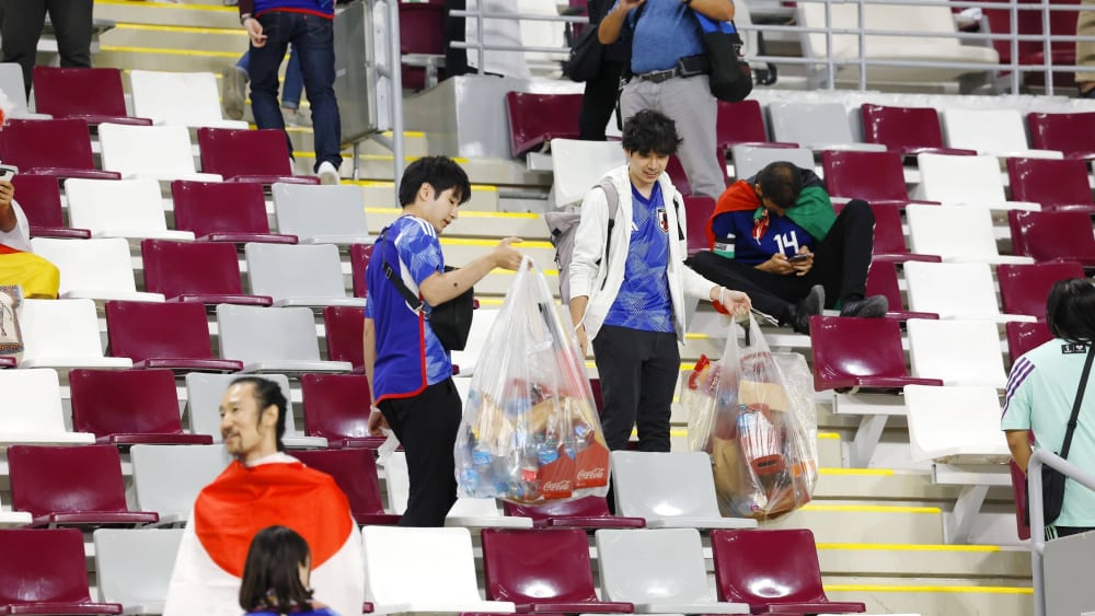 Japanische Fans sammeln Müll nach dem Sieg gegen Deutschland.