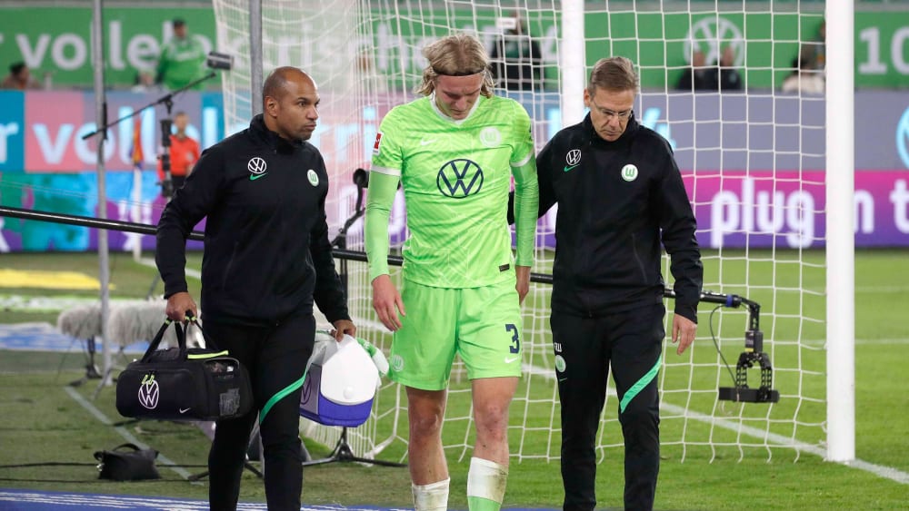 Wolfsburgs Seebastian Bornauw wird nach seiner Verletzung gegen Augsburg vom Platz begleitet.