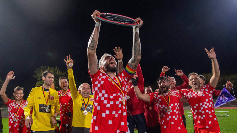 Stefen Schmidt, Kapitän von Mainz 05, reißt die Meisterschale der Amputierten-Fußball-Bundesliga in die Höhe.