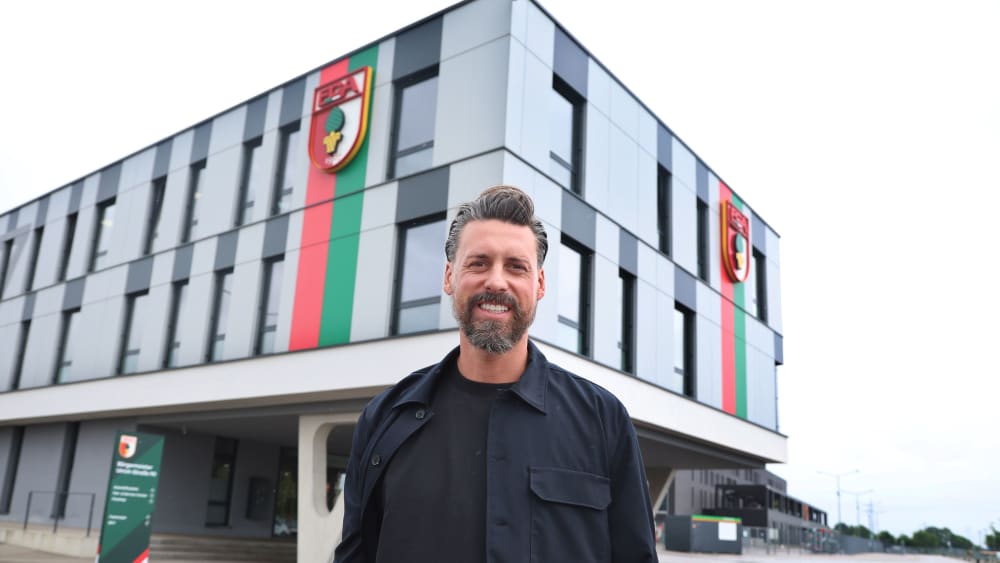 Sandro Wagner, neuer Trainer des FC Augsburg, steht vor der Geschäftsstelle des FC Augsburg.