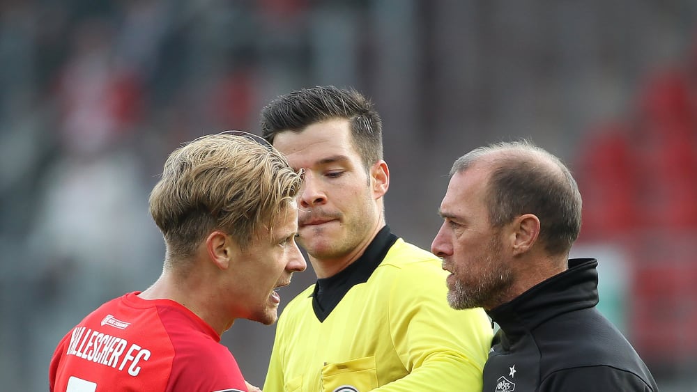 Hatten nach dem Spiel noch etwas Redebedarf: FSV Zwickau Trainer Joe Enochs (rechts) und Halle-Torschütze Bentley Baxter Bahn. (In der Mitte Schiedsrichter Harm Osmers)