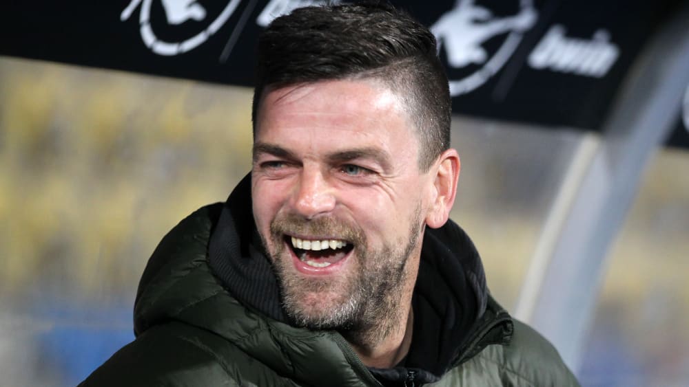 Der Coach des Halleschen FC, Torsten Ziegner, lacht gelöst auf der Trainerbank.