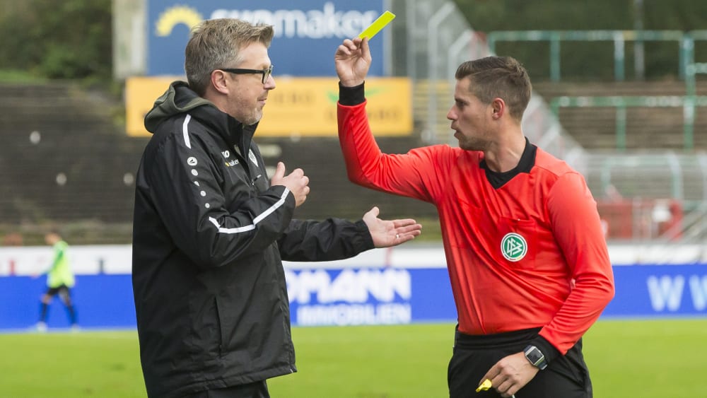 Schiedsrichter Robert Kempter (rechts) zeigt Münster-Coach Sven Hübscher die gelbe Karte.