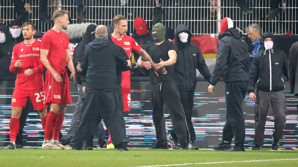 Auf Deeskalation aus: Sebastian Polter (5.v.l.) und andere Unioner beruhigen aufgebrachte Anhänger.